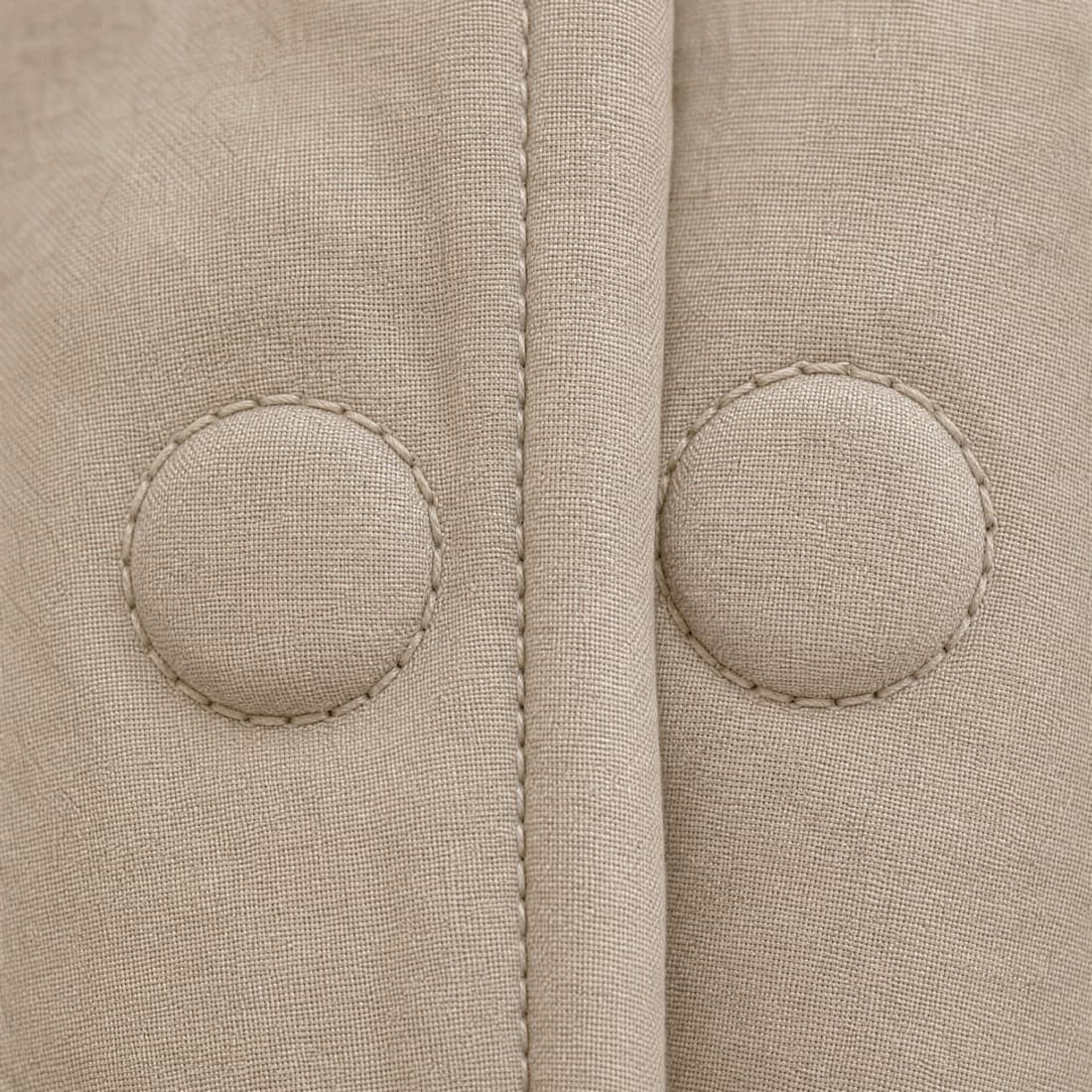Close-up of a fabric-covered magnetic closure in the aligned position: two slim rounded discs sitting flush together behind a smooth placket.